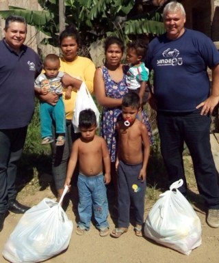 Família recebendo doação de cesta básica