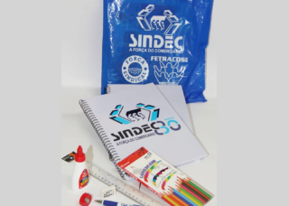 Sacola com a logomarca do Sindec, dois cadernos,um lápis, caixa de lápis de cor, apontador, borracha, régua, caneta e cola.