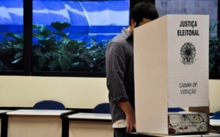 pessoa votando numa cabine de votação