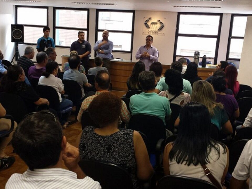 Pessoas sentadas num auditório.