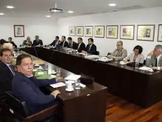 Pessoas sentadas em uma sala de reunião.