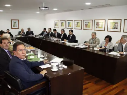 Pessoas sentadas em uma sala de reunião.