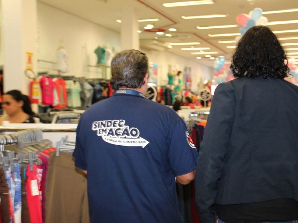 Duas pessoas de costas entrando numa loja de roupas.