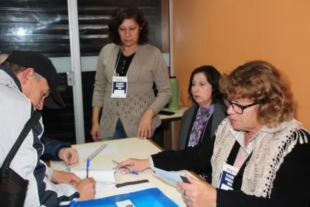 três mesárias e um senhor votando.