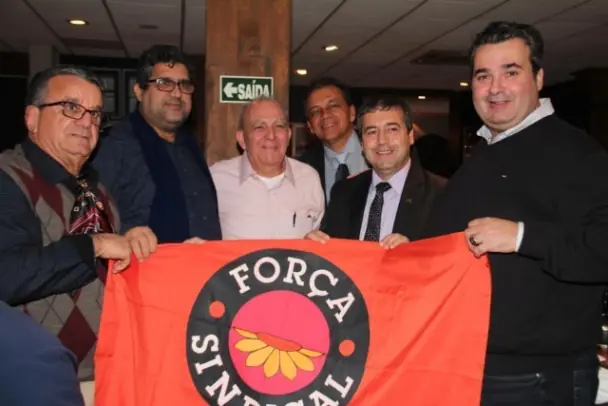 Seis homens segurando a bandeira da Força Sindical