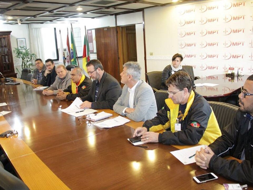 oito homens sentados em uma mesa para reunião.