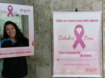 Pessoa com o rosto numa moldura. Ao lado um banner com a campanha outubro rosa.