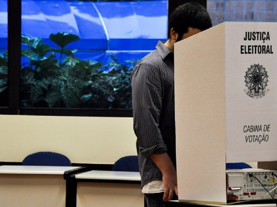 pessoa votando numa cabine de votação