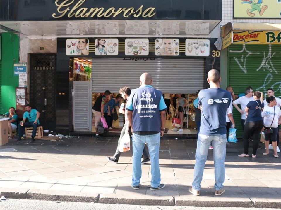 fiscais em frente a fachada de loja.