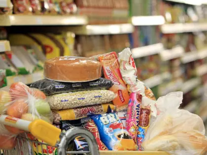 Carrinho de supermercado com vários alimentos.