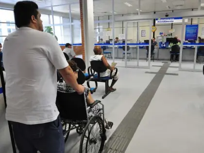 Homem empurrando uma senhora na cadeira de roda.