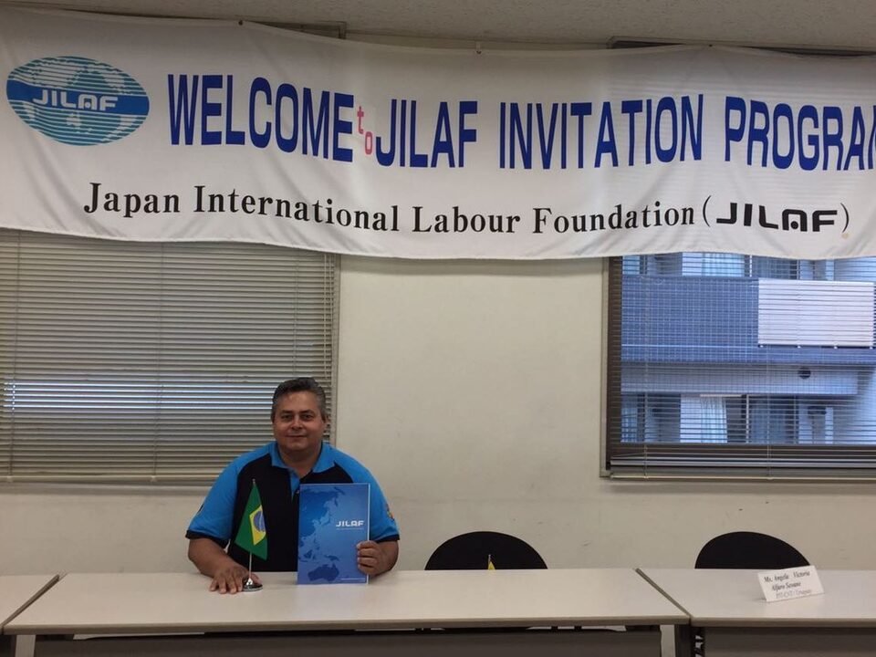 Homem sentado. Ao fundo faixa escrito: Welcome Jilaf Invitation Program