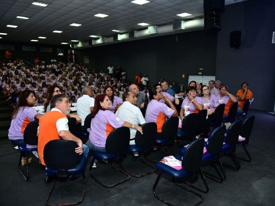 Centenas de pessoas sentadas em um auditório