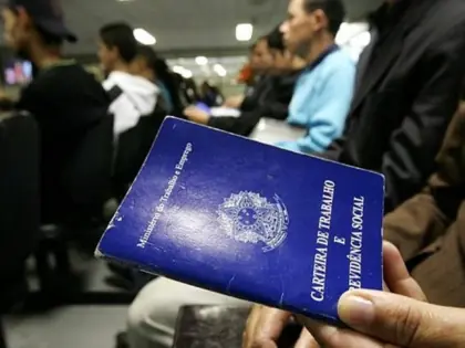 Homem segurando uma carteira de trabalho.