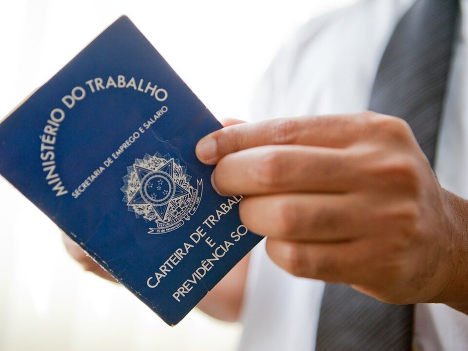 homem segurando carteira de trabalho