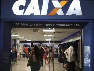 Faixada de uma agência da Caixa Econômica Federal. Pessoas entrando