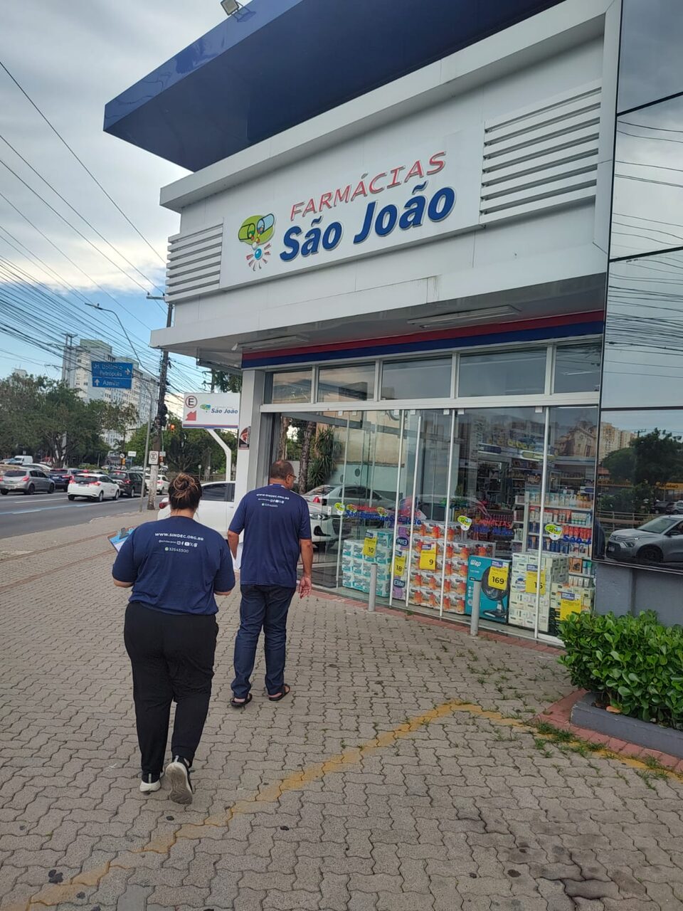 Dois fiscais do sindicato indo numa farmácia